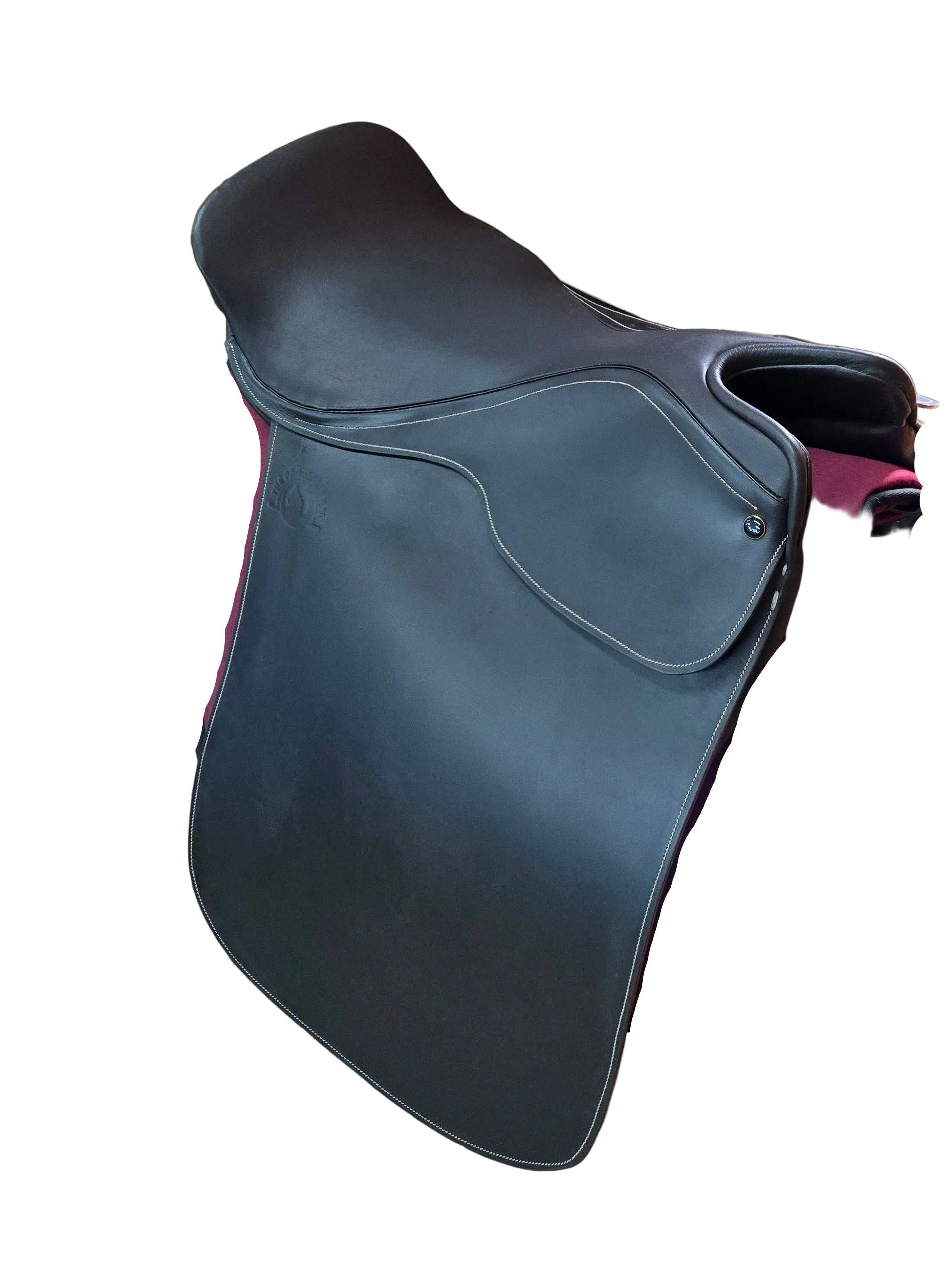 A dark brown leather equestrian saddle with a deep burgundy velvet under-saddle pad, displayed on a black metal stand inside a tiled stable room.